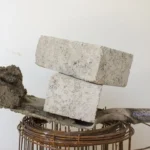 Gray blocks on shovel with bricks and cement for construction
