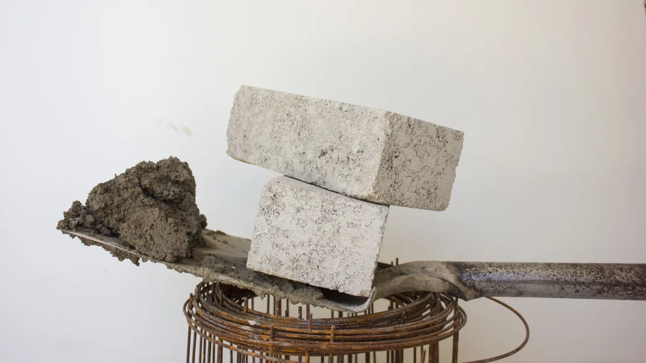 Gray blocks on shovel with bricks and cement for construction