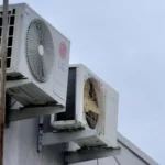 Outdoor air conditioning unit attached to building wall