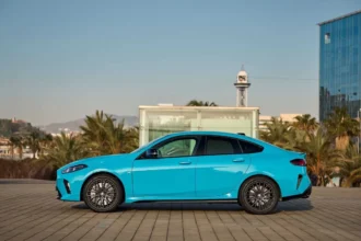 BMW i2 electric sedan parked on city street, showcasing its sleek design.