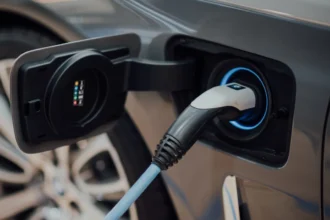 Electric vehicle charging station in black and white with USB-C cable plugged in.