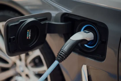 Electric vehicle charging station in black and white with USB-C cable plugged in.