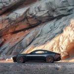Black sports car against rocky cliff during sunset highlighting luxury and adventure.