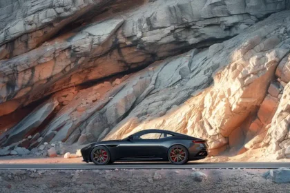 Black sports car against rocky cliff during sunset highlighting luxury and adventure.