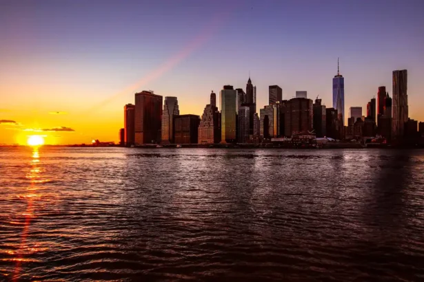City skyline of New York at sunset over water with vibrant sky