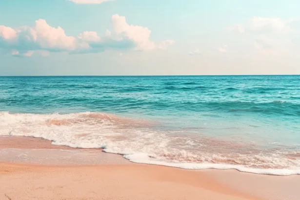 Quiet beach with golden sand, turquoise waters, and a bright sky.