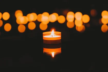 Calm candle with glow and bokeh lights creating a peaceful scene.