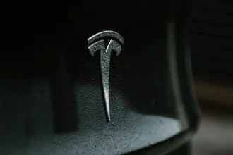 Tesla electric car with logo and Elon Musk, electric vehicle innovation.