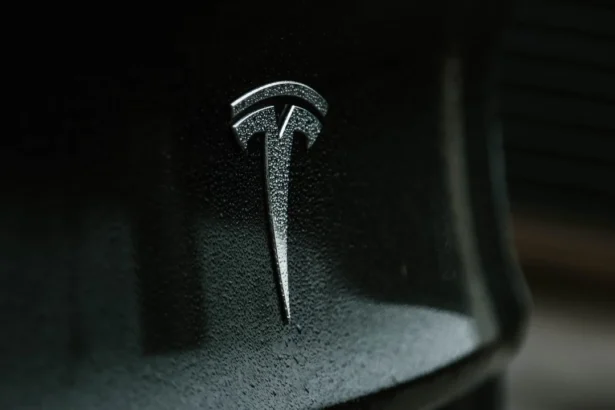 Tesla electric car with logo and Elon Musk, electric vehicle innovation.