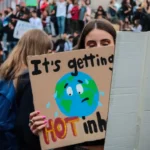 Woman holding a climate change protest sign about global warming
