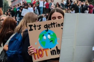 Woman holding a climate change protest sign about global warming