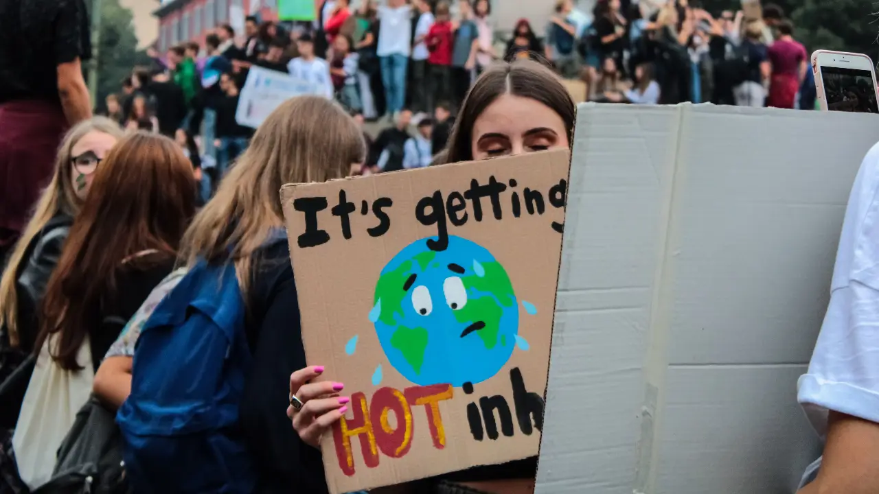 Woman holding a climate change protest sign about global warming