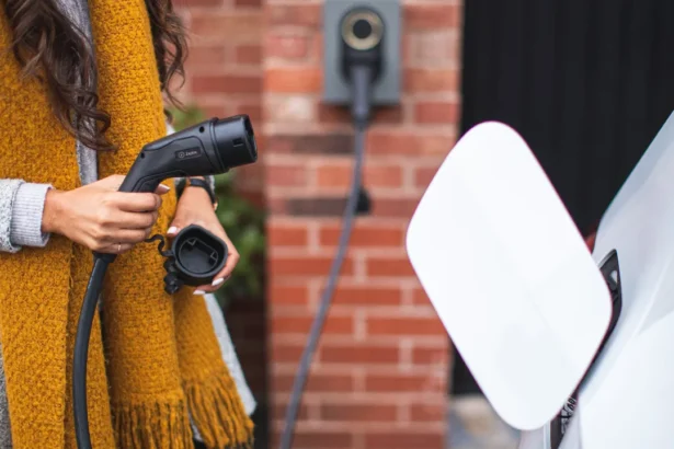 Woman plugging electric car into charger outdoors for eco-friendly travel