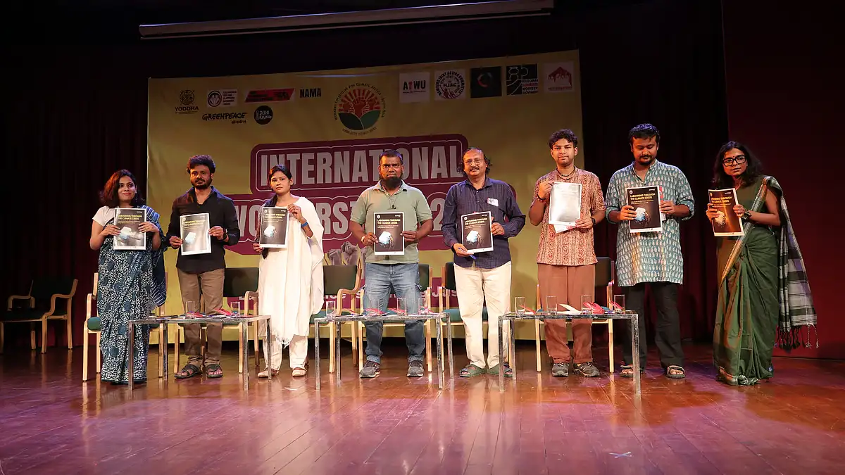 Workers from South Asia protesting for climate justice during Labour Day with signs and banners.